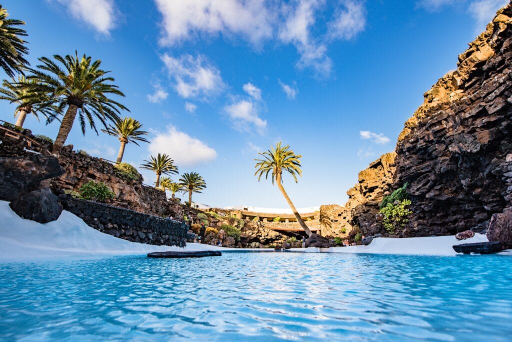 Het turquoise zwembad van Jameos del Agua tussen palmen en lavawanden